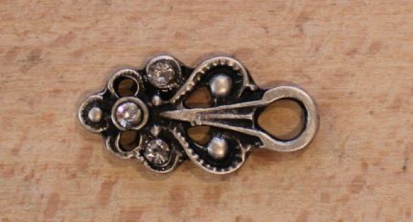 Miederknopf 24 mm mit dekorativem Schmuckstein und ornamentiertem Metallrahmen für Dirndl, Mieder und elegante Trachtenmode.